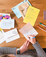 Load image into Gallery viewer, Woman writing a note on a greeting card from Friends Do This. Mildly inappropriate greeting cards for seriously rad humans.